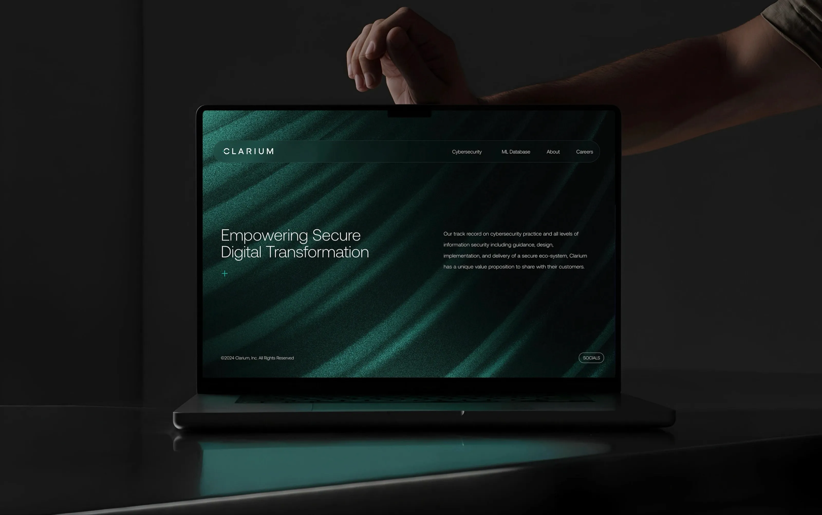 Clarium website homepage on a laptop with the dark teal brand system